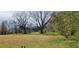 Backyard featuring a vast lawn, mature trees, a view of neighborhood homes, and a fenced-in area at 75 Doves Nest, Covington, GA 30016