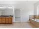 Spacious bathroom featuring double vanity, soaking tub with tile surround, and open doorway at 232 Hunt Ne St, Marietta, GA 30060