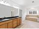 Bathroom boasts double vanity, soaking tub with tile surround, and tiled floor at 232 Hunt Ne St, Marietta, GA 30060