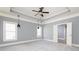 Large bedroom with tray ceilings, ceiling fan, and neutral paint at 232 Hunt Ne St, Marietta, GA 30060
