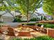 Inviting brick fire pit area with Adirondack chairs, perfect for outdoor gathering in this landscaped community at 232 Hunt Ne St, Marietta, GA 30060