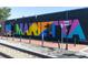 Colorful Marietta mural on a black brick wall next to train tracks at 232 Hunt Ne St, Marietta, GA 30060