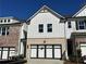 Charming townhome with a two-car garage, brick facade and white siding on a sunny day at 259 Depot Landing Rd # 40, Auburn, GA 30011