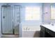 A bathroom featuring a glass enclosed shower, soaking tub and window at 912 Tanners Point Dr, Lawrenceville, GA 30044