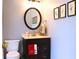 Stylish half bath with a modern vanity, oval mirror, and fresh, neutral décor at 912 Tanners Point Dr, Lawrenceville, GA 30044