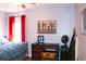 Bedroom featuring red curtains, a desk, and a queen-sized bed with blue bedding at 912 Tanners Point Dr, Lawrenceville, GA 30044