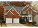 Beautiful brick home featuring a two-car garage, classic architecture, and lush landscaping at 912 Tanners Point Dr, Lawrenceville, GA 30044