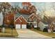 Charming two-story brick home featuring a two-car garage and a well-manicured front yard with mature trees at 912 Tanners Point Dr, Lawrenceville, GA 30044