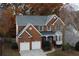 Traditional brick two-story home boasts green shutters, manicured landscaping, and a two-car garage at 912 Tanners Point Dr, Lawrenceville, GA 30044