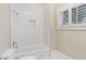 Bright bathroom featuring tiled shower and tub, built-in niche, and shuttered window for added privacy at 281 15Th Ne St # 101, Atlanta, GA 30309