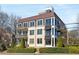 Multi-story building with multiple balconies and large windows overlooking the beautifully landscaped yard at 281 15Th Ne St # 101, Atlanta, GA 30309