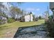 Expansive backyard showcasing lawn space, trees, and the back exterior of the house on a sunny day at 1143 Forest Villa Nw Dr, Conyers, GA 30012