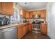 Efficient kitchen with stainless steel appliances, light wood cabinets, and laminate floors at 1143 Forest Villa Nw Dr, Conyers, GA 30012