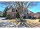 Traditional two-story home with brick and siding, mature trees and a circular flower bed at 2160 Kensington Gates Nw Dr, Kennesaw, GA 30152