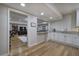 Open-concept kitchen with white cabinets, granite countertops, and a breakfast bar that connects to the living area at 2160 Kensington Gates Nw Dr, Kennesaw, GA 30152