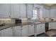 Close up of a kitchen with a tile backsplash, stainless steel appliances, granite countertops, and white cabinets at 2160 Kensington Gates Nw Dr, Kennesaw, GA 30152
