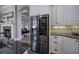 Kitchen features stainless steel refrigerator, white cabinets, granite countertops and a view of the fireplace at 2160 Kensington Gates Nw Dr, Kennesaw, GA 30152