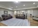 Spacious living room features plush leather sofas, hardwood floors, and an open floor plan leading to a kitchen at 2160 Kensington Gates Nw Dr, Kennesaw, GA 30152