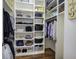 Organized walk-in closet with custom shelving and hardwood floors at 2160 Kensington Gates Nw Dr, Kennesaw, GA 30152