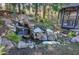 This backyard boasts a tranquil waterfall feature surrounded by rocks and greenery near a shaded gazebo at 2160 Kensington Gates Nw Dr, Kennesaw, GA 30152