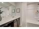 Bathroom vanity with framed mirror and a tub with white shower curtain at 264 Depot Landing Rd # 50, Auburn, GA 30011