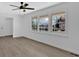 Bedroom with large windows showing neighborhood, ceiling fan, and light wood flooring at 3679 Mill Glen Dr, Douglasville, GA 30135