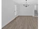 Empty room with stairs, french doors, a modern light fixture, and light wood flooring at 3679 Mill Glen Dr, Douglasville, GA 30135