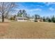 Expansive front lawn view showcasing the white home, adjacent house, and tree-lined street at 3679 Mill Glen Dr, Douglasville, GA 30135