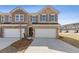 Beautiful brick two-story townhouse featuring a two-car garage and a well-manicured front yard at 935 Elwood St, Dacula, GA 30019