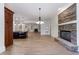 Open-concept living room featuring a stone fireplace, wood floors, and modern lighting at 1364 Manget Way, Dunwoody, GA 30338