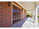 Inviting covered porch with brick facade, wood deck, and traditional columns at 1364 Manget Way, Dunwoody, GA 30338