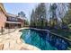 Gorgeous in-ground swimming pool is surrounded by a stone patio and a safety fence, offering a relaxing outdoor space at 1364 Manget Way, Dunwoody, GA 30338