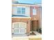 Charming townhome showcasing a brick facade, attached garage, and cozy front porch entry at 47 Trailside Cir, Hiram, GA 30141