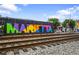Colorful Marietta mural on a building near train tracks, enhancing the area's artistic appeal at 549 Trailwood Sw Ln, Marietta, GA 30064