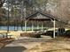 Outdoor pavilion area with picnic tables and grill near the tennis court at 549 Trailwood Sw Ln, Marietta, GA 30064