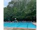 Community pool with a slide and seating, surrounded by mature trees at 549 Trailwood Sw Ln, Marietta, GA 30064