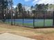 A fenced-in tennis court with a green and blue surface at 549 Trailwood Sw Ln, Marietta, GA 30064