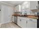 Updated kitchen features stainless steel dishwasher, white cabinets, and a window above the sink at 1875 Ebenezer Sw Rd, Conyers, GA 30094