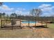 Backyard view of an above ground pool surrounded by a wooden deck and a wood and wire fence on a sunny day at 1875 Ebenezer Sw Rd, Conyers, GA 30094