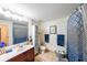 Well-lit bathroom with a large mirror, a sink with cherry vanity, and patterned shower curtain at 230 E Ponce De Leon Ave # 327, Decatur, GA 30030