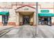 An inviting building entrance with brick pillars and decorative planters, complemented by nearby shops and awnings at 230 E Ponce De Leon Ave # 327, Decatur, GA 30030