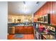 Well-equipped kitchen with cherry wood cabinets, stainless steel appliances, and black countertops at 230 E Ponce De Leon Ave # 327, Decatur, GA 30030