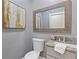 Bathroom with a gray vanity, granite countertop, neutral paint, decorative framed mirror, and toilet at 695 Old Peachtree Rd, Lawrenceville, GA 30043