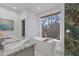 Bright bathroom featuring a soaking tub, a window with natural light, and marble countertops at 695 Old Peachtree Rd, Lawrenceville, GA 30043
