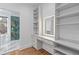 Bathroom vanity featuring a lighted mirror, drawers, and shelving with adjacent glass shower at 695 Old Peachtree Rd, Lawrenceville, GA 30043