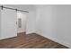 Cozy bedroom featuring wood floors and a modern sliding barn door at 695 Old Peachtree Rd, Lawrenceville, GA 30043