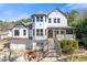 Two-story home showcasing a prominent front tower, gray roof, front porch, manicured landscaping, and an attached two-car garage at 695 Old Peachtree Rd, Lawrenceville, GA 30043