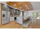 Open kitchen with hardwood floors, modern island, stainless appliances, and a wood-paneled ceiling at 695 Old Peachtree Rd, Lawrenceville, GA 30043