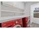 Modern laundry room with white shelving and vibrant red washer/dryer units at 695 Old Peachtree Rd, Lawrenceville, GA 30043