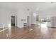 Open-concept living space with light wood floors and view of fireplace and the kitchen with stainless steel appliances at 695 Old Peachtree Rd, Lawrenceville, GA 30043
